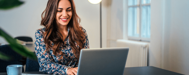 cheerful-woman-using-laptop-workplace