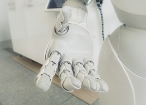 closeup photo of white robot arm. "You can do everything by yourself," Nabil states, "but is it the right use of your time?"