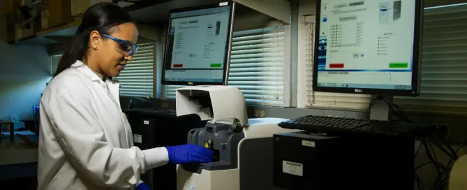 Healthcare Software Teams: woman standing in a lab, using DNA Genotyping and Sequencing machines and apps