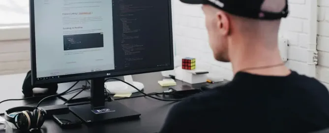 Nearshore App Development For Marketplace Companies: man reading a tutorial qhile fixing code