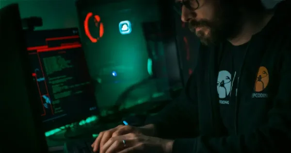 Services Tech Stacks: man in black jacket using computer in a gamer setup in a dark room