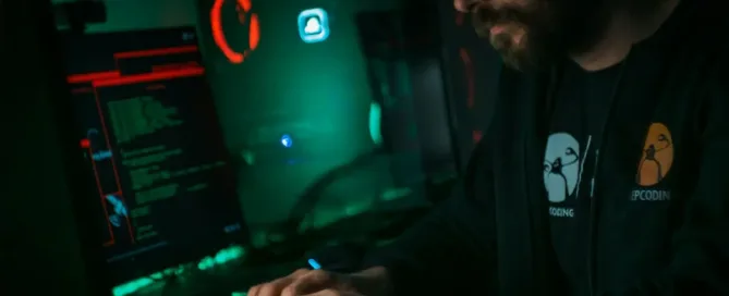 Services Tech Stacks: man in black jacket using computer in a gamer setup in a dark room