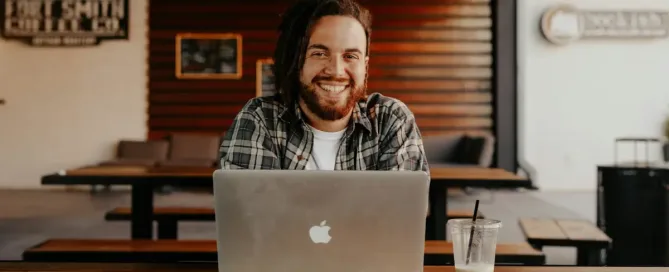 Cost-Effective Hiring: man in black and white striped polo shirt sitting on chair in front of silver macbook