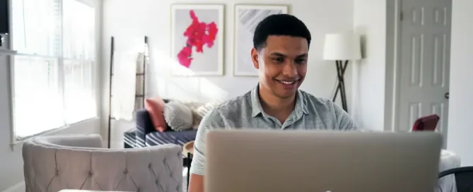 Cybersecurity & Fraud Prevention: man in gray hoodie sitting on chair in front of silver macbook