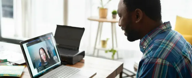 Man using laptop at a desk in a modern workspace. Learn the skills needed to thrive in the future of work.