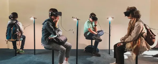 Diverse group of people using VR headsets in a gallery setting, representing user-centered design in AR/VR development.