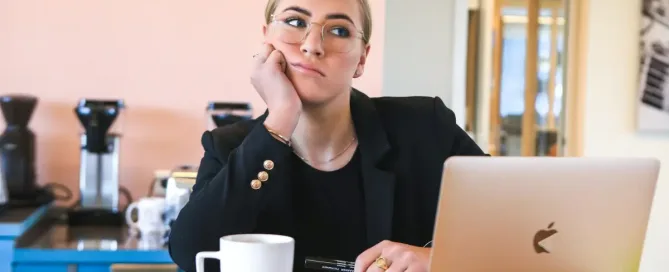 Tech recruiter looking bored while waiting at a desk. Exploring the challenges and opportunities presented by a hiring freeze.