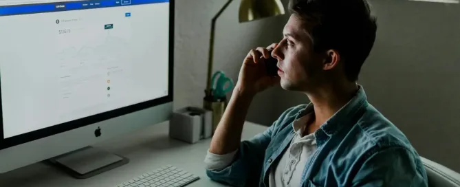 Manager looking seriously at a computer screen with financial data, symbolizing the challenges of employee performance management.