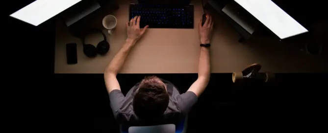 optimized for coding workflow: man facing three computer monitors while sitting