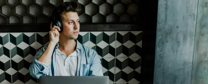 distributed software team performance: developer sitting in front of silver MacBook, looking thoughtfully at the horizon