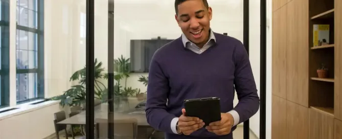 hidden staffing costs: a man standing in an office looking at a tablet