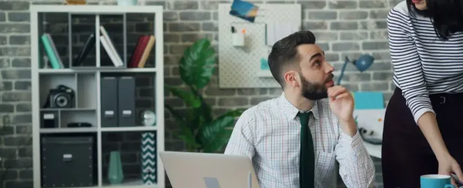 hire a programmer: Young man working with laptop then talking to coworker pretty woman in office