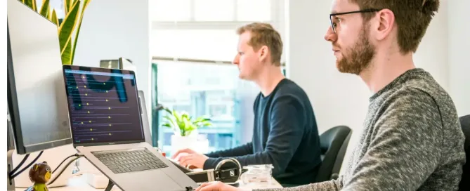 ai for software development: developers working hard - man sitting on chair wearing gray crew-neck long-sleeved shirt using Apple Magic Keyboard