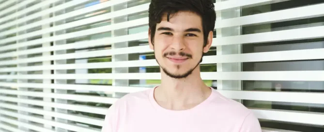 gcp engineer standing near window, smiling at camera