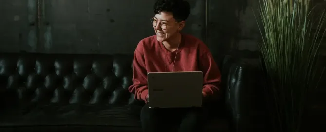 hire android developers: smiling man using laptop computer while sitting on black leather sofa