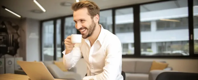 HR manager drinks coffee and smiles while looking at ATS Software