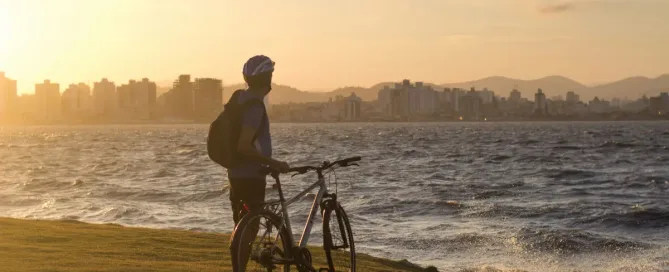 Countries in Latin America: Engineer and his bike overlook Florianopolis sea-bound skyline