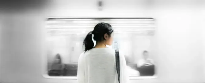 H-1B Visa Lottery: woman in white elbow-sleeved shirt standing near white train in subway