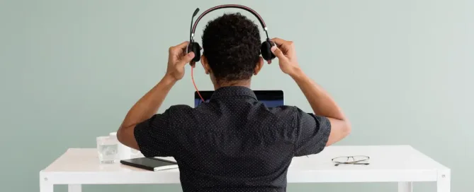 US Tech Interviews: Black person puts on headphones and prepares to enter video call.