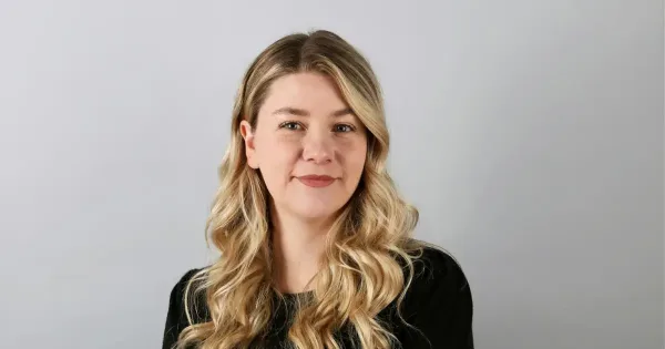 digital currency: a woman with long blonde hair wearing a black shirt smiles at camera