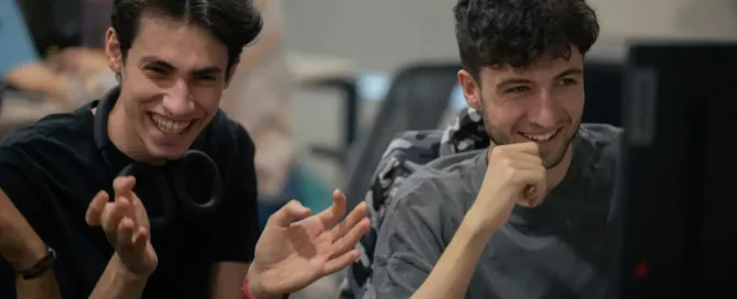 Launch Feature Flags: Two Developers meeting in front of screen and laughing over code