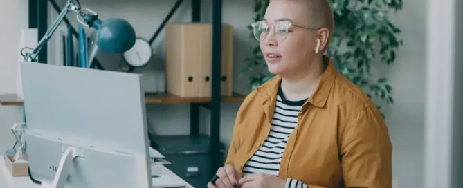 Legacy UI Redesign: UX/UI Designer standing in front of a laptop computer, during a team call