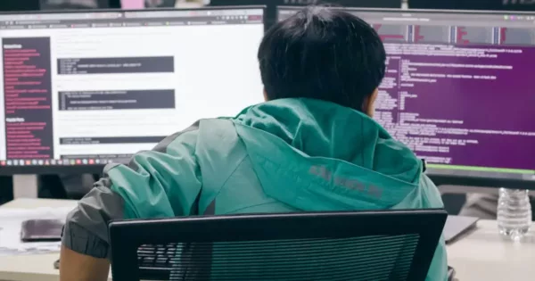 Reduce Developer Turnover: a tired engineer sitting in front of two computer monitors