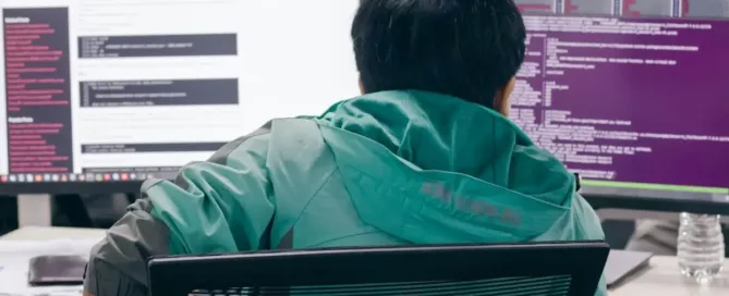 Reduce Developer Turnover: a tired engineer sitting in front of two computer monitors