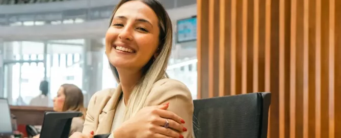 Risk and Compliance in Software Teams: A smiling legal team member sitting at a desk with her arms crossed
