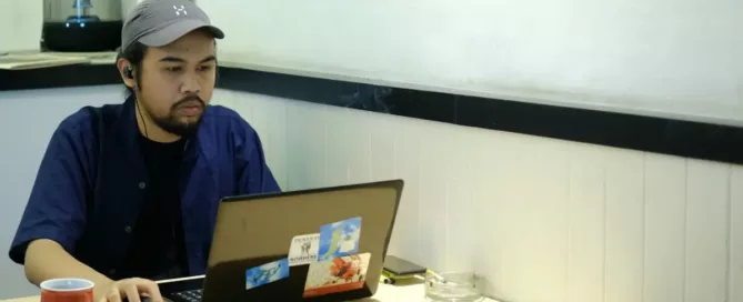 fast-developer-hiring: An Ubiminder working in front of a laptop on a cafe