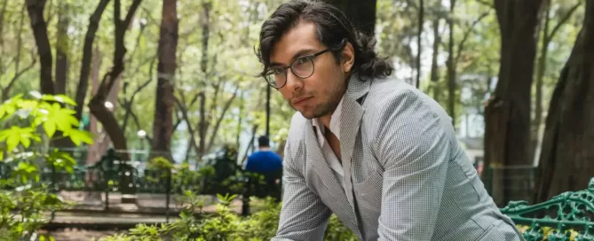 time-to-hire delays: SaaS founder outdoors sitting in a park bench with a thoughtful face.