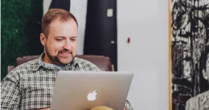 FinTech Team:man smiling and using MacBook