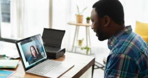 Man using laptop at a desk in a modern workspace. Learn the skills needed to thrive in the future of work.