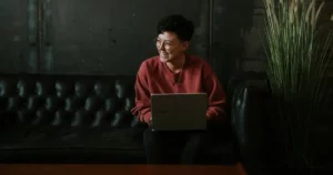 hire android developers: smiling man using laptop computer while sitting on black leather sofa