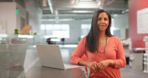 Job evaluation: woman in orange long sleeve shirt sitting beside table with macbook pro